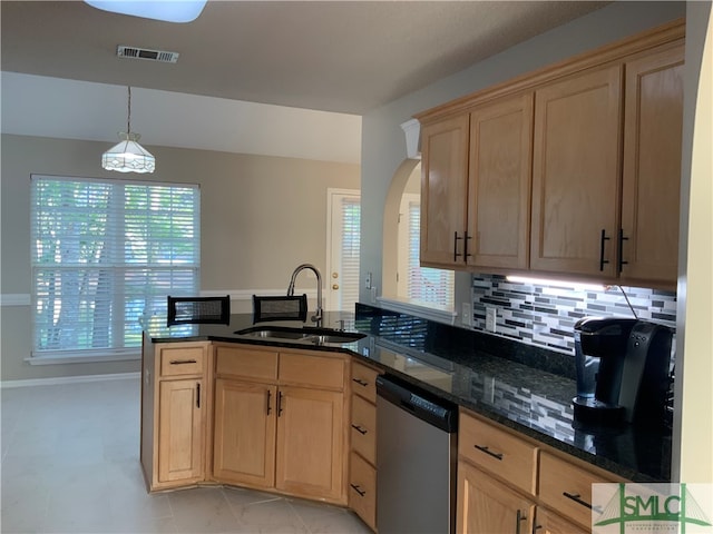 kitchen with dark stone counters, decorative light fixtures, light tile floors, dishwasher, and sink