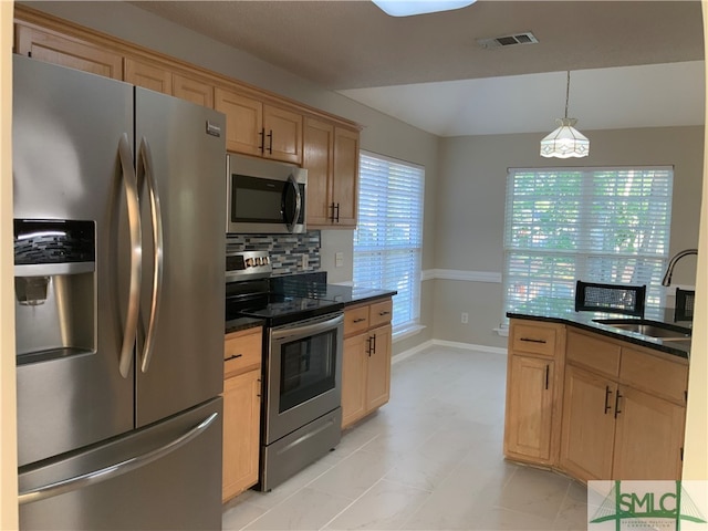 kitchen featuring pendant lighting, stainless steel appliances, light tile floors, backsplash, and sink