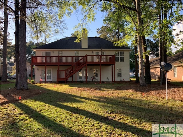 back of property with a deck, french doors, and a lawn