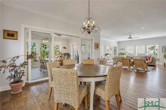 dining area featuring ceiling fan with notable chandelier, ornamental molding, and hardwood / wood-style flooring