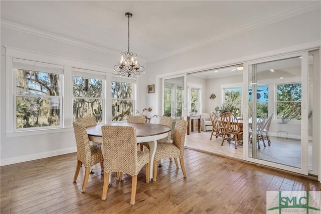 dining room with plenty of natural light, hardwood / wood-style floors, a chandelier, and ornamental molding