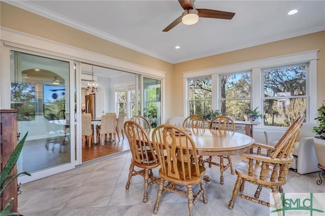 tiled dining area featuring ceiling fan with notable chandelier and crown molding