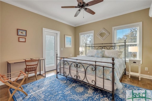 bedroom featuring ornamental molding, wood-type flooring, ceiling fan, and a wall mounted AC