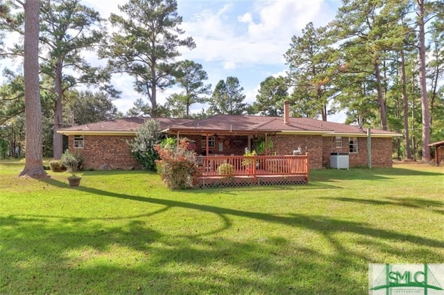 back of house featuring a deck and a lawn