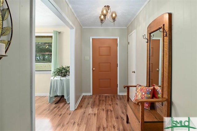 interior space featuring light wood-type flooring, crown molding, and an inviting chandelier