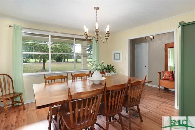 dining room featuring hardwood / wood-style flooring, ornamental molding, and a notable chandelier