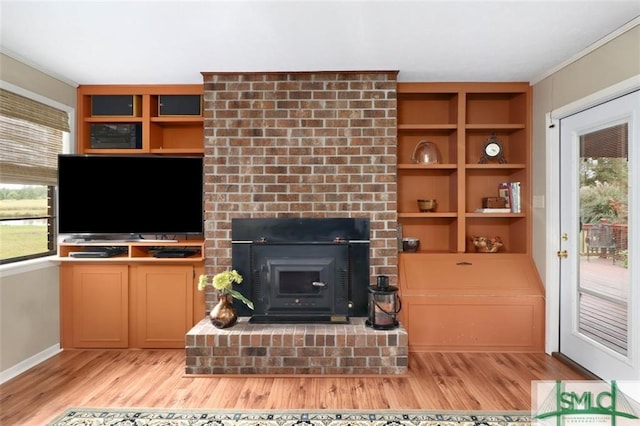 living room with ornamental molding, a healthy amount of sunlight, and light hardwood / wood-style floors