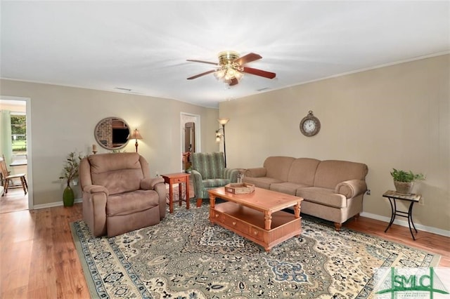 living room with wood-type flooring, ceiling fan, and crown molding