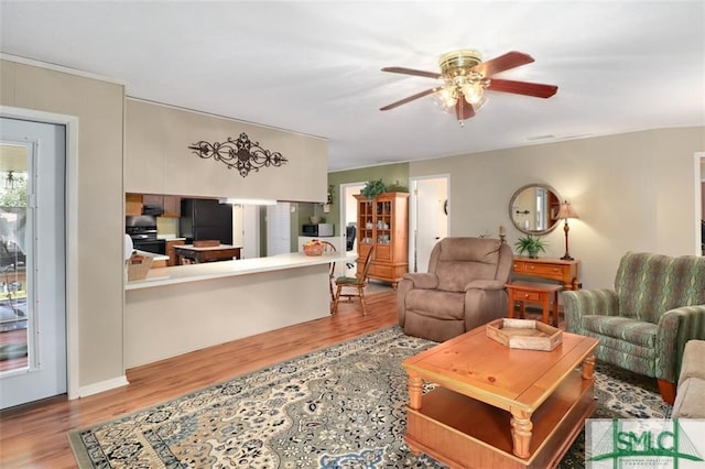 living room with ceiling fan and light wood-type flooring