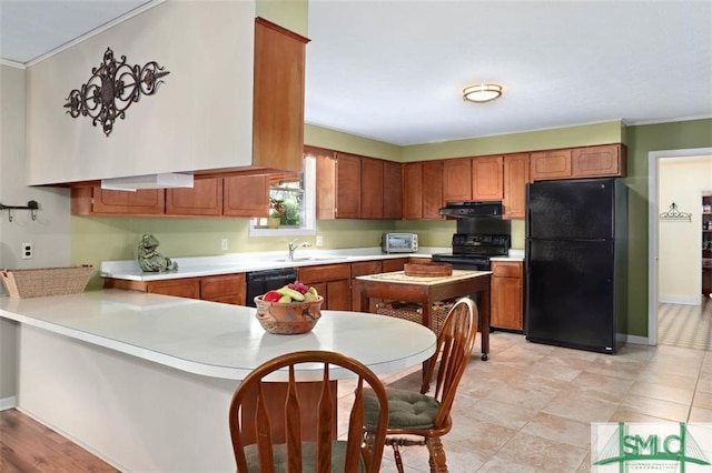 kitchen with sink, kitchen peninsula, crown molding, extractor fan, and black appliances