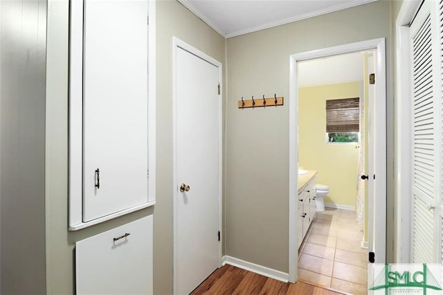 hallway featuring crown molding and light hardwood / wood-style flooring