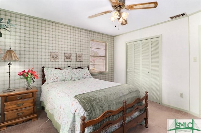 carpeted bedroom with ceiling fan and a closet