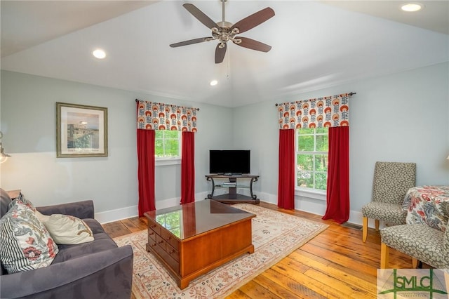 living room with ceiling fan, light hardwood / wood-style floors, and lofted ceiling