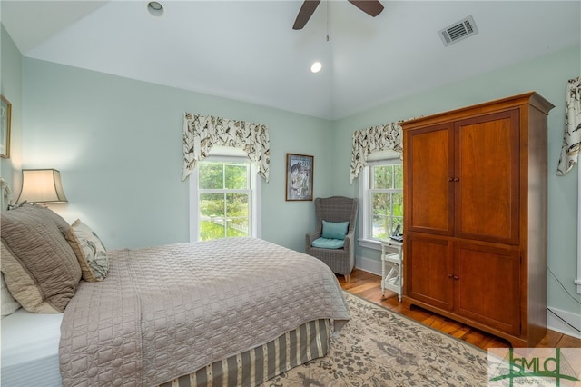 bedroom with ceiling fan, light hardwood / wood-style floors, and vaulted ceiling