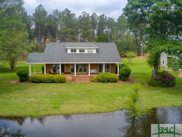 view of front of property with a front yard, a porch, and a water view