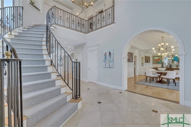 entryway featuring light hardwood / wood-style floors, a high ceiling, and a chandelier