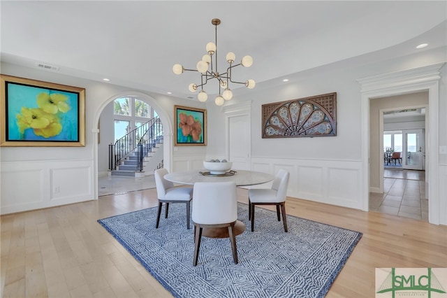 dining space with an inviting chandelier, a healthy amount of sunlight, and light hardwood / wood-style floors