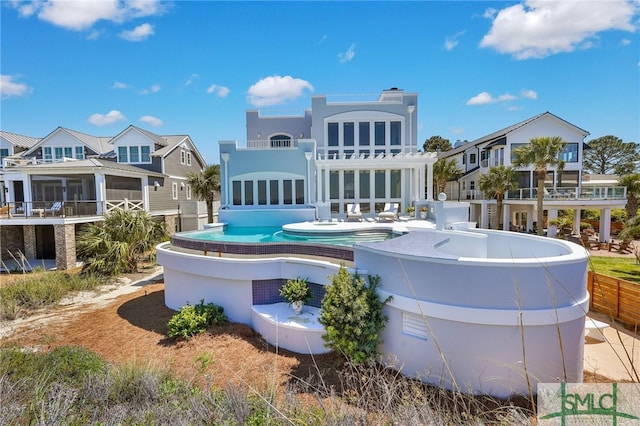 back of property featuring a balcony and a swimming pool