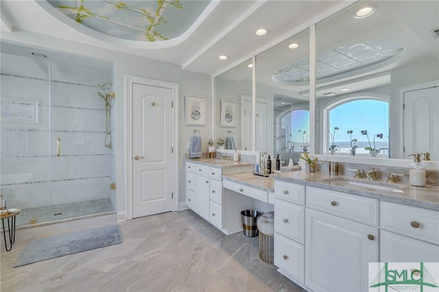 bathroom with tile flooring, a shower with shower door, vanity, and a tray ceiling