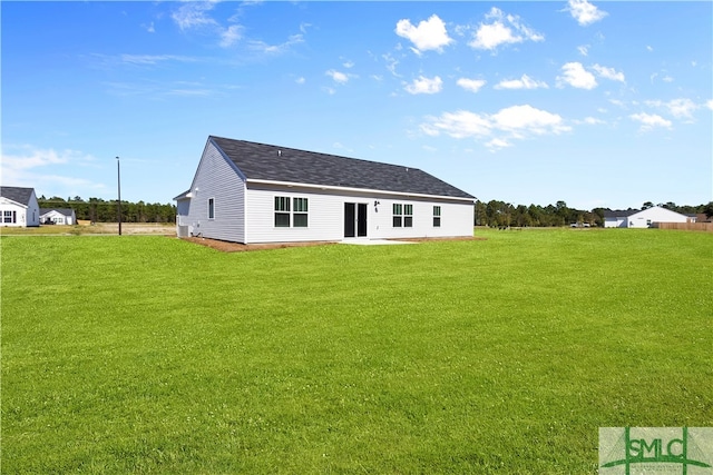 rear view of property featuring a lawn