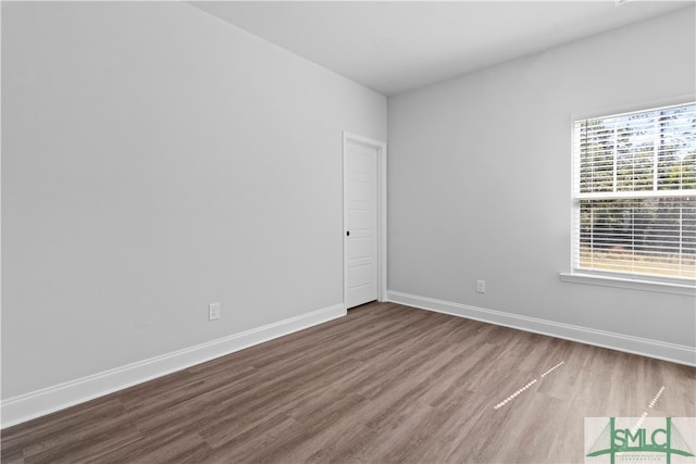 unfurnished room featuring a healthy amount of sunlight and hardwood / wood-style flooring