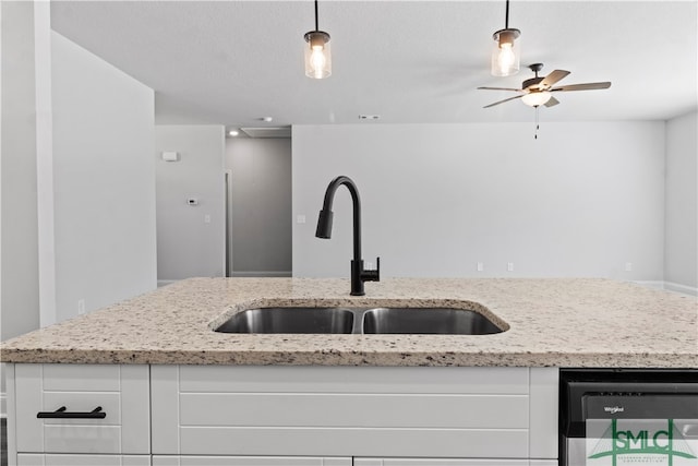 kitchen with white cabinetry, light stone countertops, sink, and decorative light fixtures