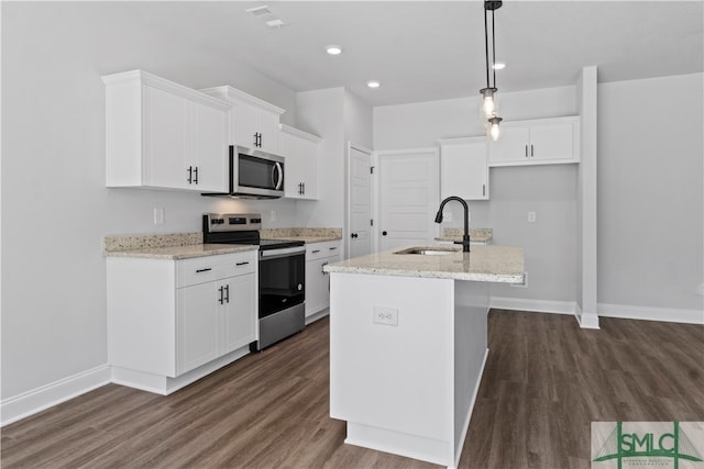 kitchen with stainless steel appliances, sink, an island with sink, and dark hardwood / wood-style floors