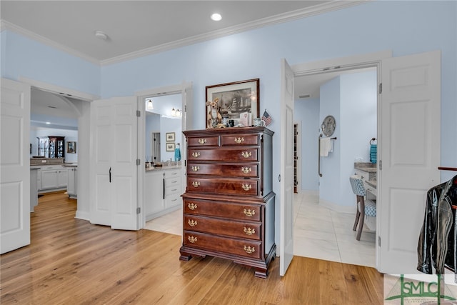 hallway featuring ornamental molding and light hardwood / wood-style flooring