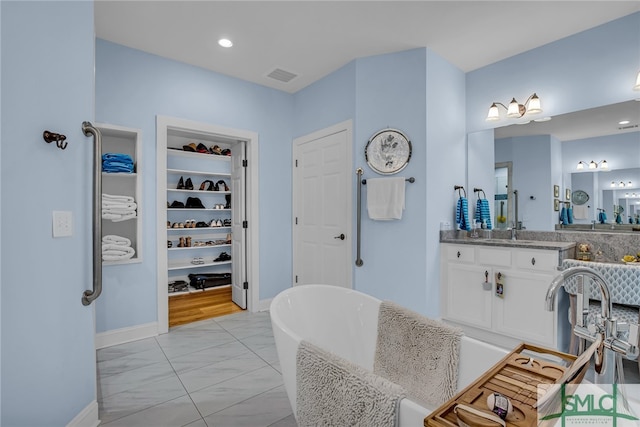 bathroom featuring vanity, tile floors, and a tub