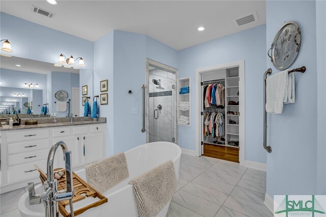 bathroom with shower with separate bathtub, vanity, and tile floors