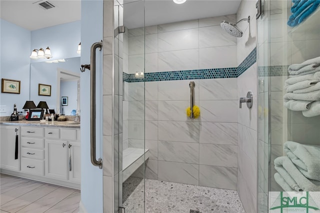 bathroom featuring tile flooring, oversized vanity, and a shower with shower door