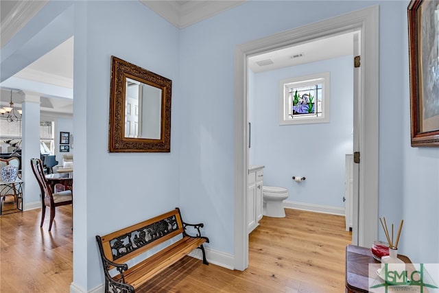 interior space with crown molding, an inviting chandelier, and light hardwood / wood-style floors