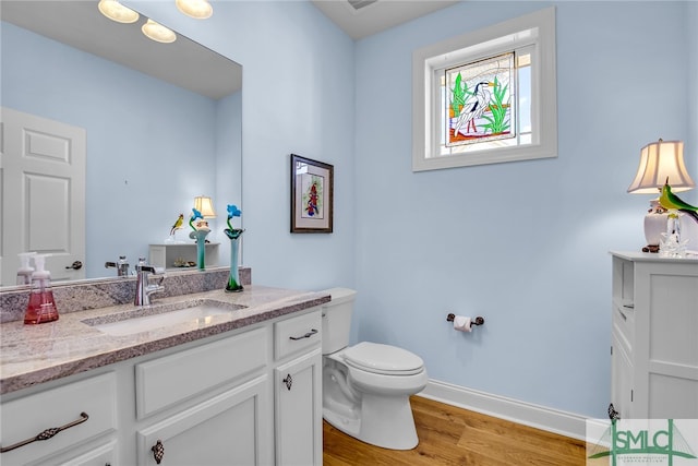 bathroom with vanity, hardwood / wood-style floors, and toilet