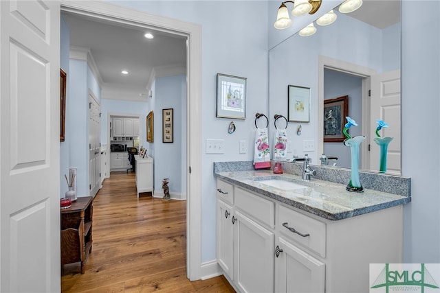 bathroom featuring crown molding, vanity, and hardwood / wood-style floors