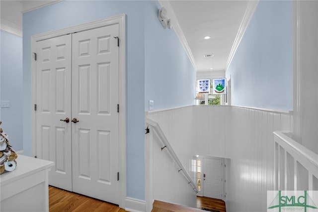 hallway with crown molding and light wood-type flooring