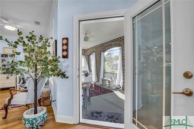 entryway featuring ceiling fan, crown molding, and light hardwood / wood-style floors