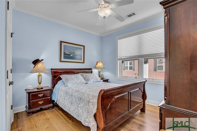 bedroom with crown molding, light hardwood / wood-style floors, and ceiling fan