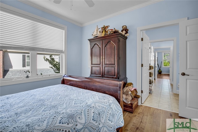 tiled bedroom featuring ceiling fan and crown molding