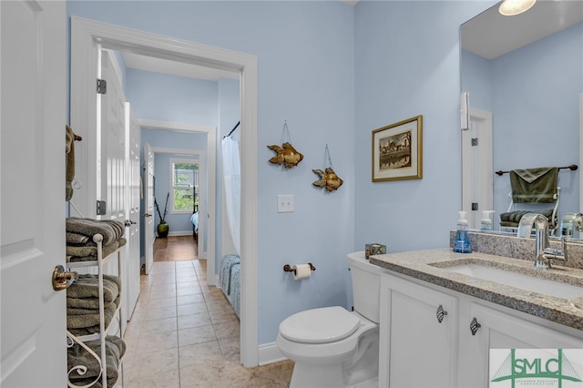 bathroom featuring toilet, large vanity, and wood-type flooring