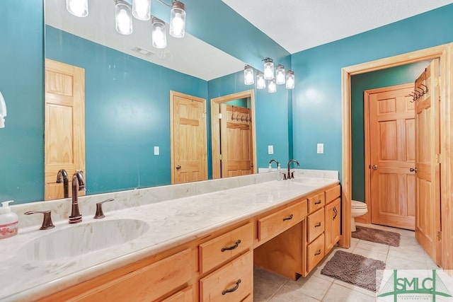 bathroom featuring dual sinks, tile floors, toilet, and large vanity