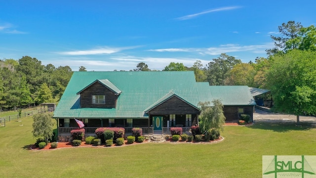 log cabin with a front yard and covered porch