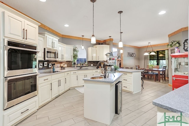 kitchen featuring backsplash, appliances with stainless steel finishes, pendant lighting, a kitchen island with sink, and ornamental molding