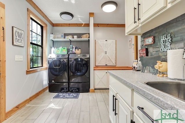 washroom featuring sink, cabinets, and washer and clothes dryer