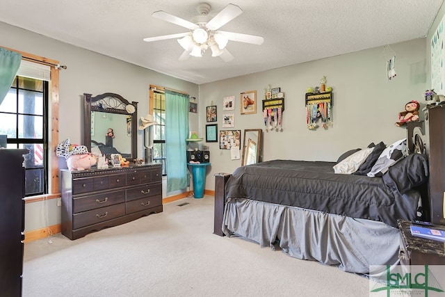 carpeted bedroom with ceiling fan and a textured ceiling