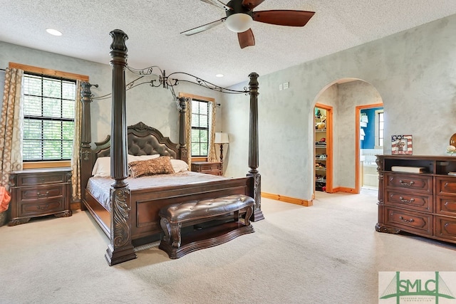 bedroom with light colored carpet, a textured ceiling, and ceiling fan