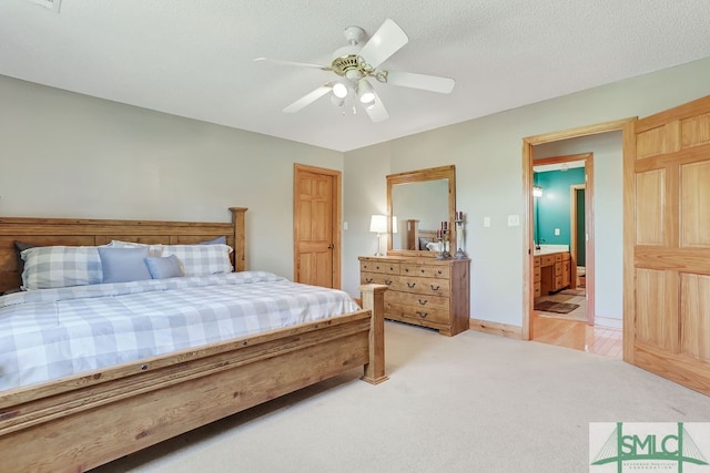 carpeted bedroom featuring ceiling fan, a textured ceiling, and ensuite bathroom