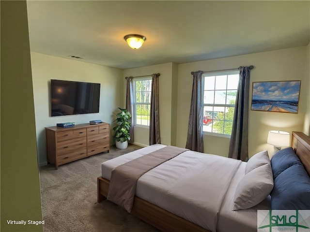 bedroom featuring light carpet and multiple windows