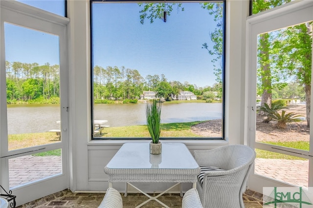 sunroom / solarium with plenty of natural light and a water view