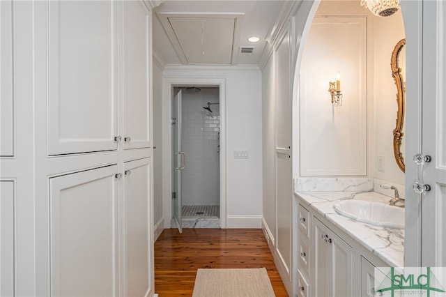 bathroom with wood-type flooring, a shower with door, and vanity