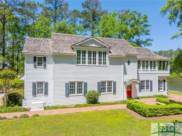 colonial house with a front lawn and a balcony